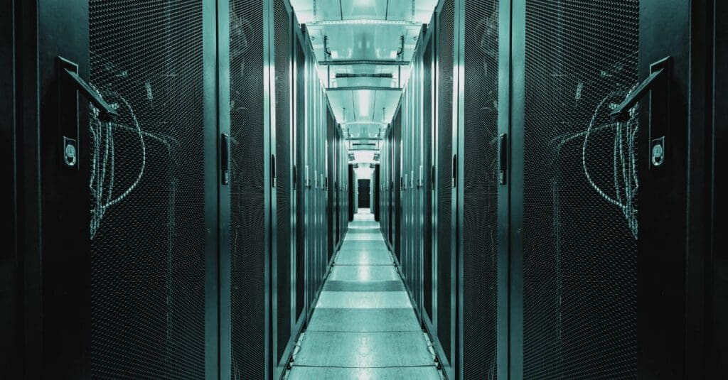 Interior of a modern data centre with rows of server racks, highlighting the importance of efficient, sustainable infrastructure in the digital age. Navitas Resourcing Group connects top talent for green data centre projects.