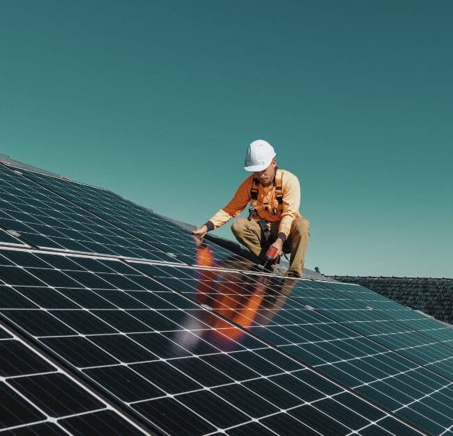 A technician working on solar panels, helping to drive the clean energy revolution. Navitas Resourcing Group connects top talent to solar energy projects.