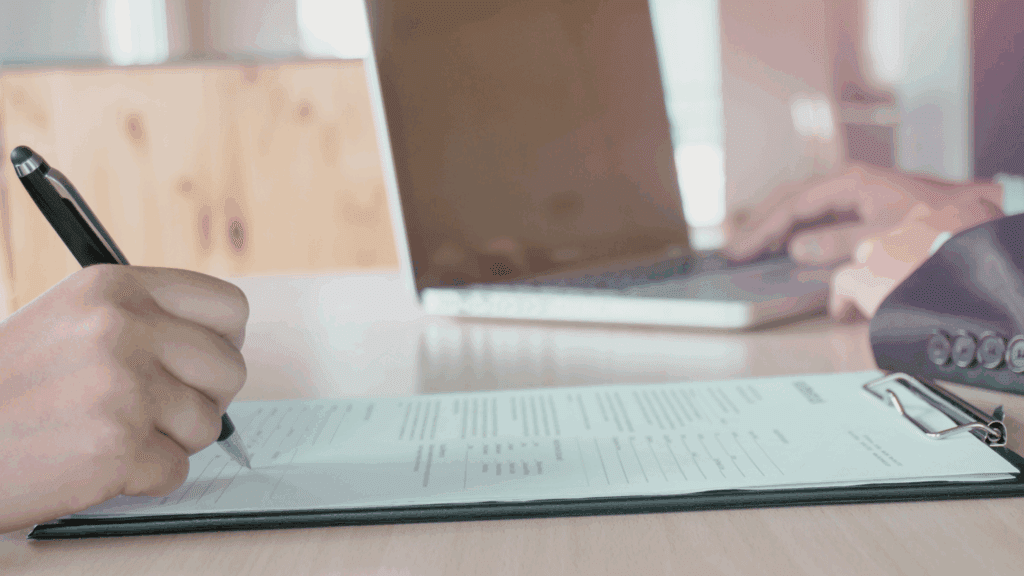 Renewable energy professional reviewing their CV on a laptop, with wind turbines in the background, representing career opportunities in the clean energy sector.