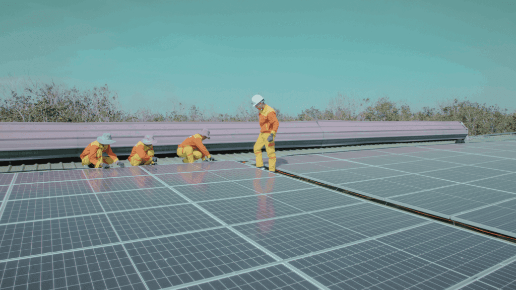 Workers installing solar panels on a large utility-scale project site, symbolising the rapid growth of U.S. solar capacity and demand for renewable energy talent in 2025.