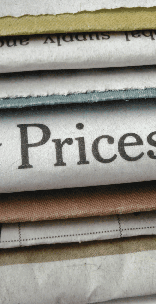 A close-up of a newspaper headline reading “Energy Prices Surge”, representing the impact of rising electricity costs on the UK’s net zero goals and renewable workforce.