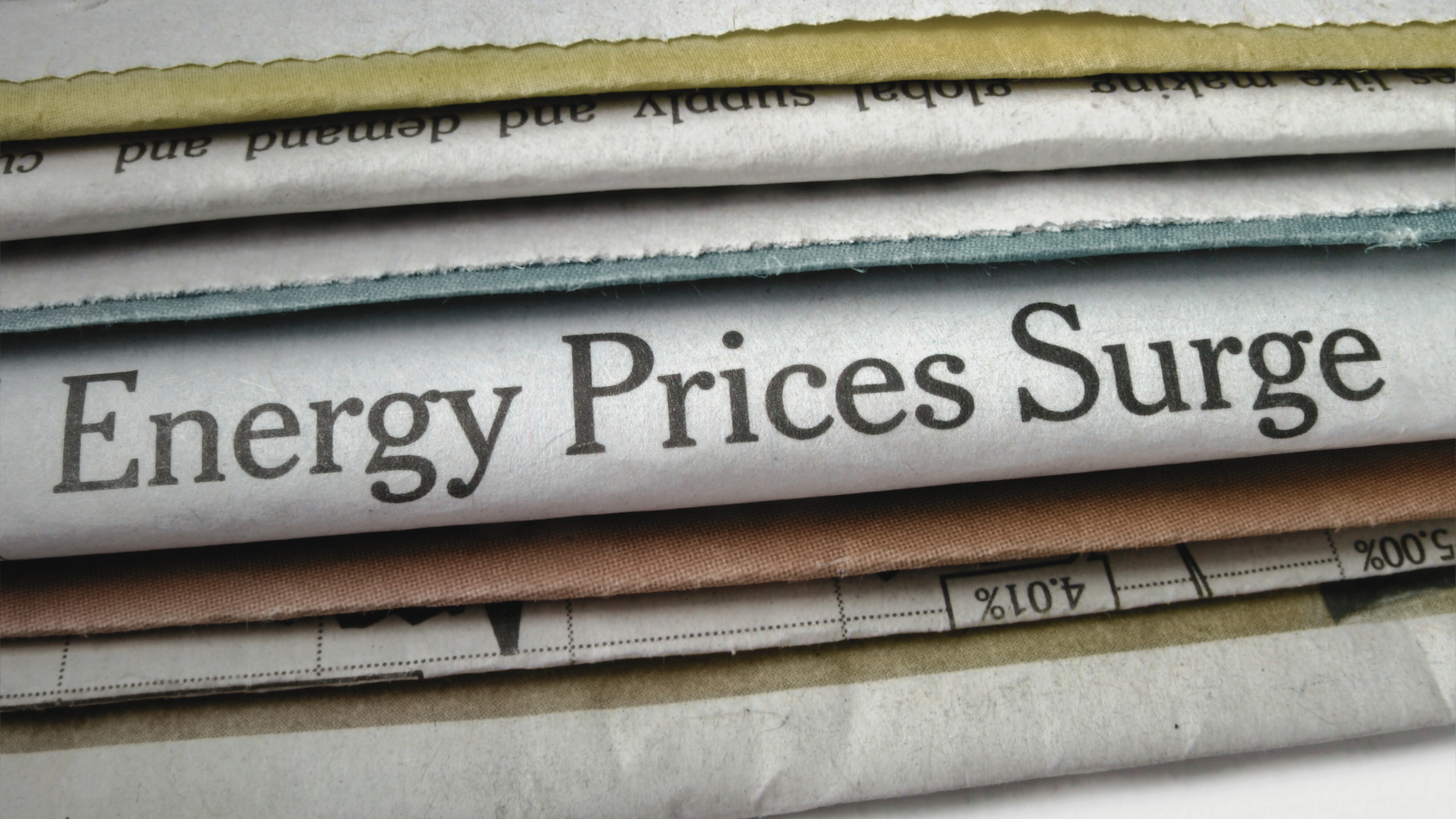 A close-up of a newspaper headline reading “Energy Prices Surge”, representing the impact of rising electricity costs on the UK’s net zero goals and renewable workforce.